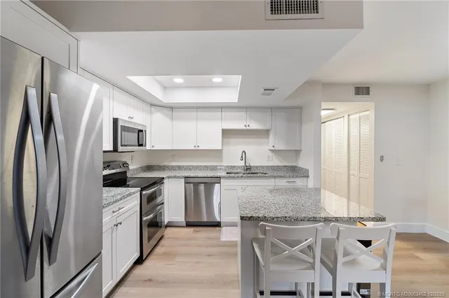 a kitchen with granite countertop a sink stove and cabinets