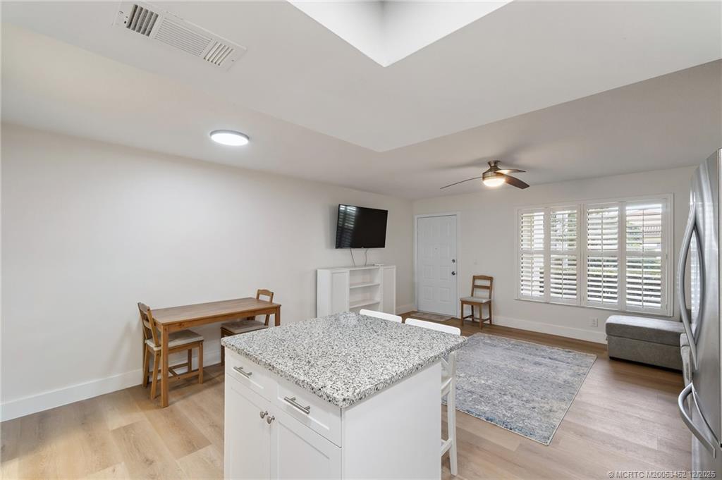511 Southwest South River Drive, Unit 104 Stuart, FL 34997 - Photo 21 of 61 a living room with a couch and a flat screen tv