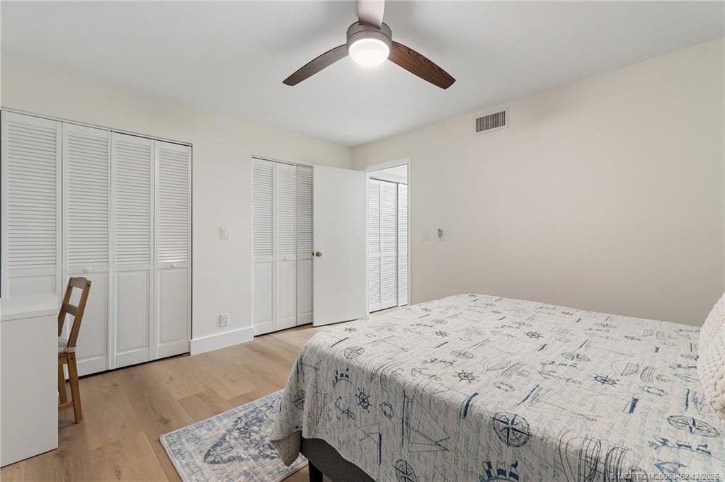 511 Southwest South River Drive, Unit 104 Stuart, FL 34997 - Photo 29 of 61 a bedroom with a bed and a chandelier