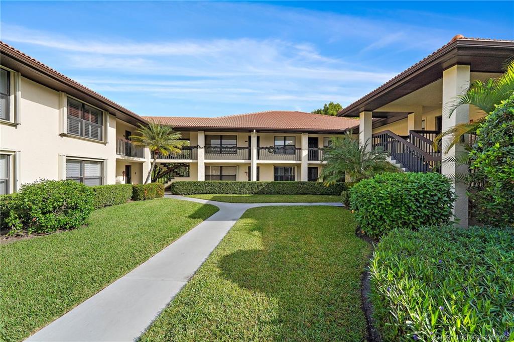 511 Southwest South River Drive, Unit 104 Stuart, FL 34997 - Photo 3 of 61 a front view of a house with a yard