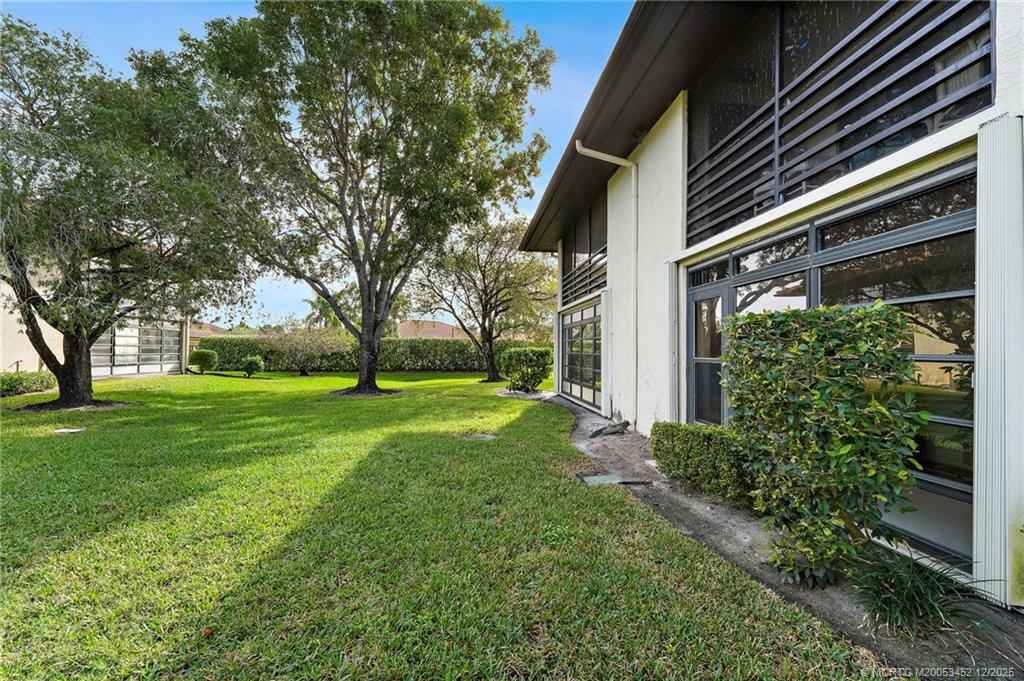 511 Southwest South River Drive, Unit 104 Stuart, FL 34997 - Photo 37 of 61 a view of a yard with plants and large trees