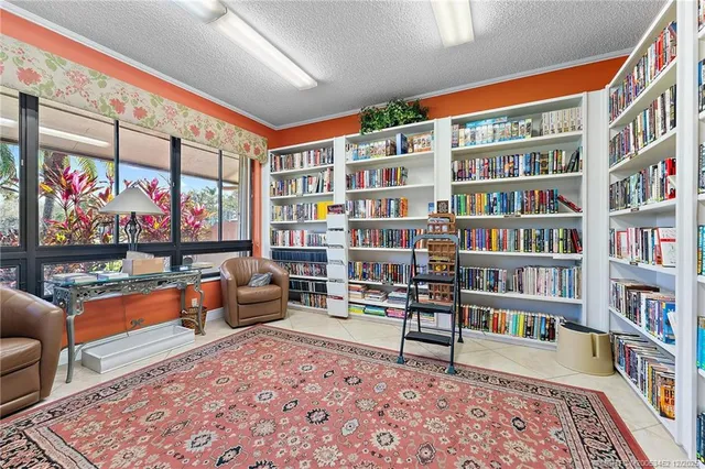 a living room filled with furniture and kitchen view