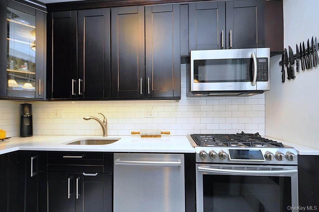 281 Garth Road, Unit A5L Scarsdale, NY 10583 - Photo 14 of 46 a kitchen with a stove and a microwave