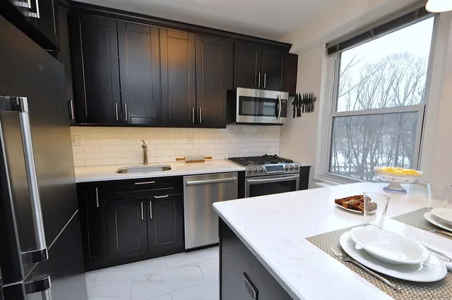 a kitchen with a sink a stove a microwave and wooden floor