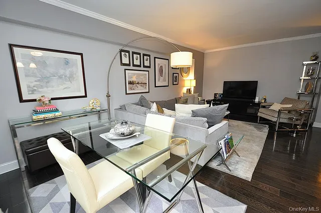 a dining room with furniture a wooden floor and a flat screen tv