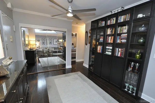 a living room with stainless steel appliances furniture a rug and a view of kitchen