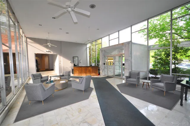 a living room with furniture large window and flat screen tv