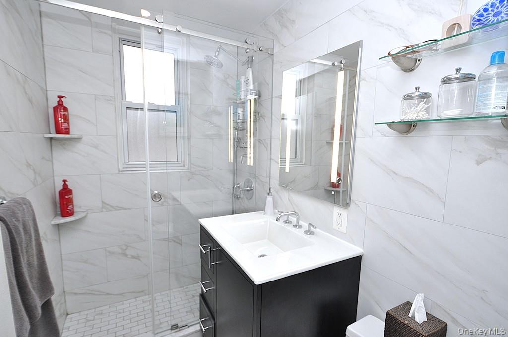 281 Garth Road, Unit A5L Scarsdale, NY 10583 - Photo 4 of 46 a bathroom with a sink vanity and a shower