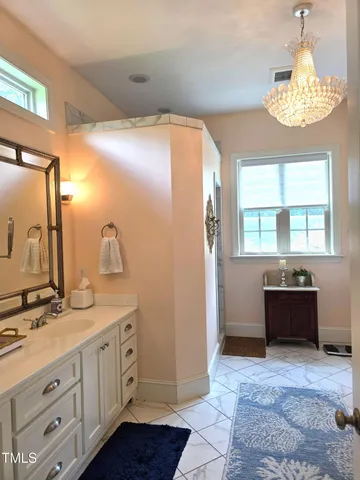 a spacious bathroom with a granite countertop sink a mirror and a bathtub