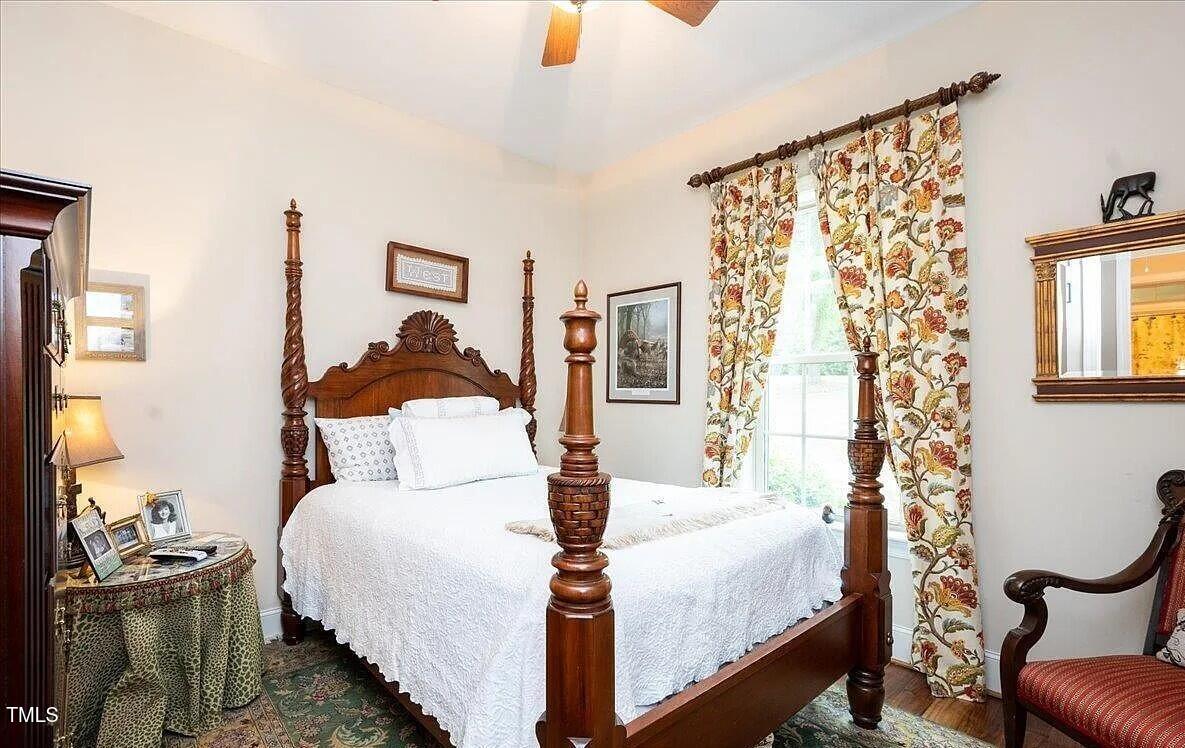 413 Johnson Town Road Zebulon, NC 27597 - Photo 33 of 52 a bedroom with a bed and a chandelier