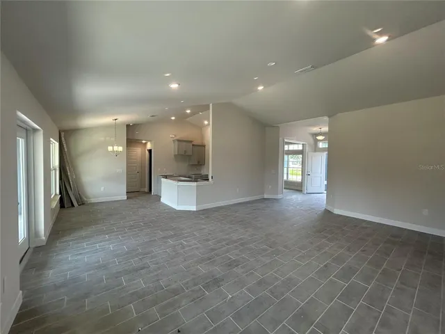 a view of a big room with windows and chandelier
