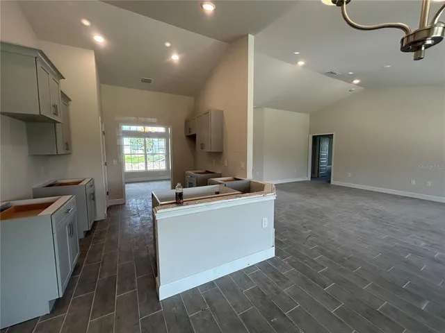 a large kitchen with stainless steel appliances a large counter top a stove and a refrigerator