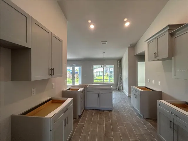 a kitchen with granite countertop a sink stove and cabinets