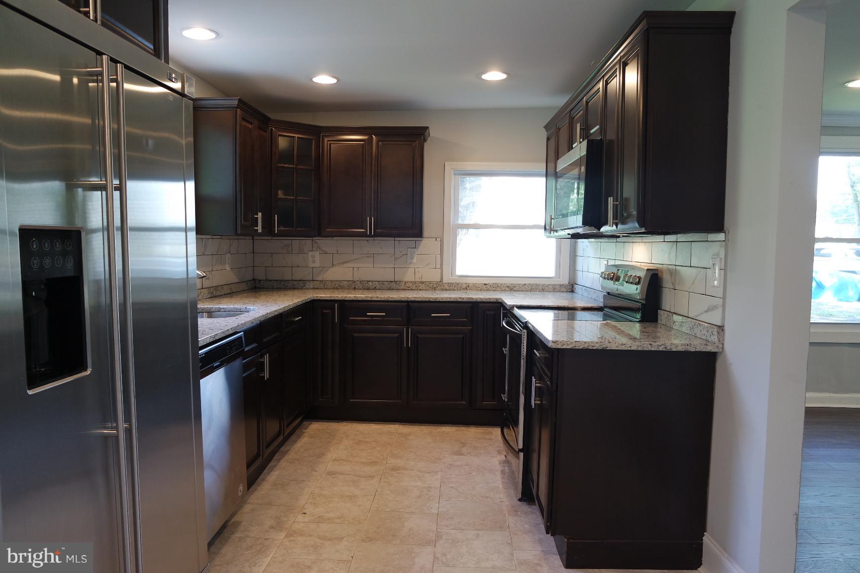 421 Bryan Point Road Accokeek, MD 20607 - Photo 3 of 17 a kitchen with stainless steel appliances granite countertop refrigerator a sink a stove and microwave