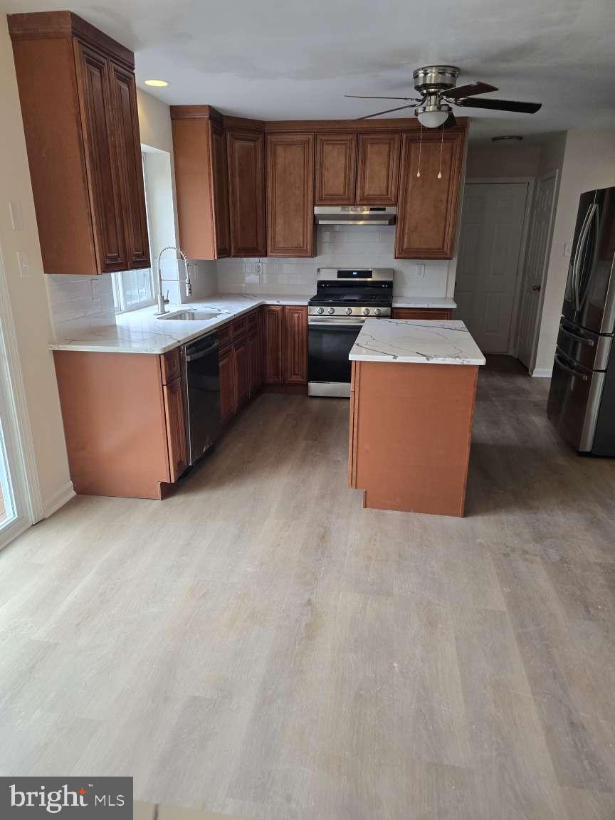 10 Osprey Lane Middletown, DE 19709 - Photo 7 of 25 a room with kitchen island a sink a stove and a refrigerator