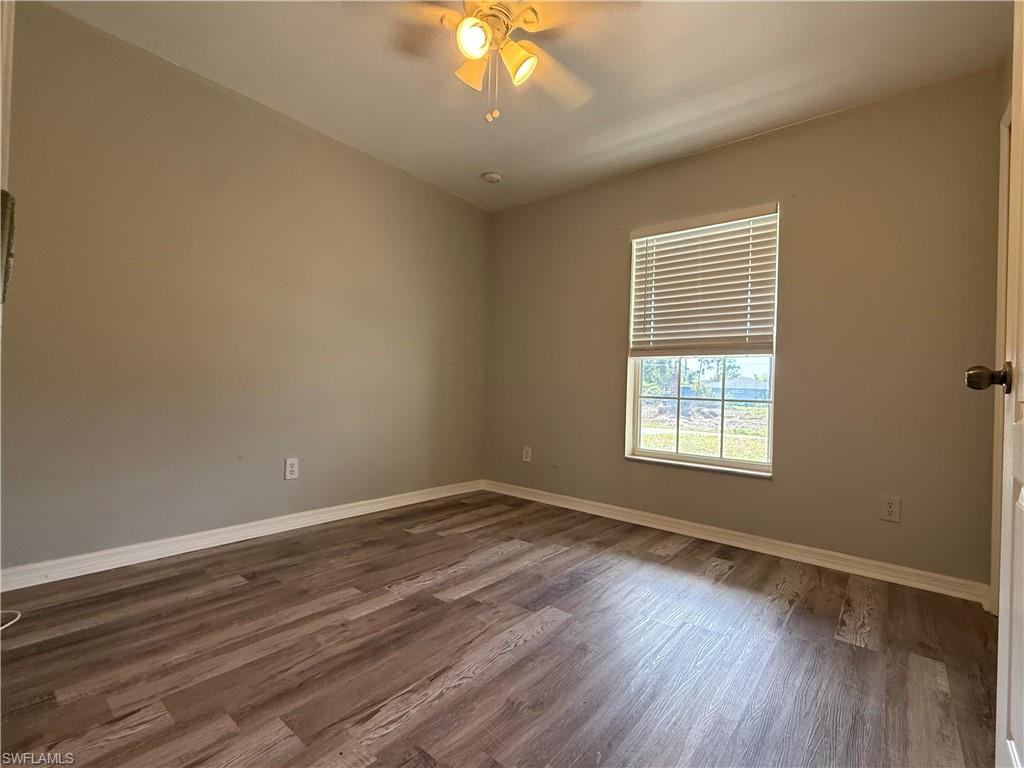 3122 12th Street Southwest Lehigh Acres, FL 33976 - Photo 14 of 19 a view of an empty room with wooden floor and a window