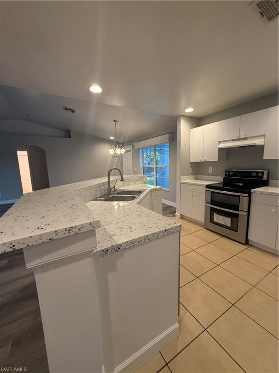 3122 12th Street Southwest Lehigh Acres, FL 33976 - Photo 4 of 19 a kitchen with granite countertop a sink and a stove top oven with wooden floor
