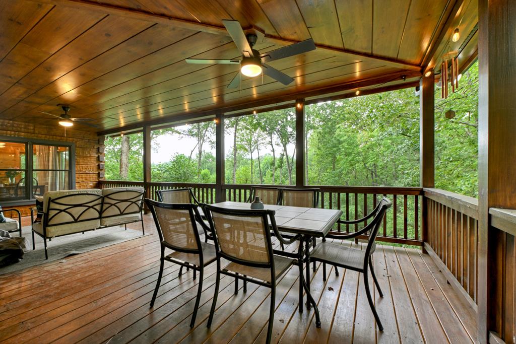 1134 Maggie Chapman Road Blue Ridge, GA 30513 - Photo 31 of 65 a view of a patio with a table chairs and wooden floor