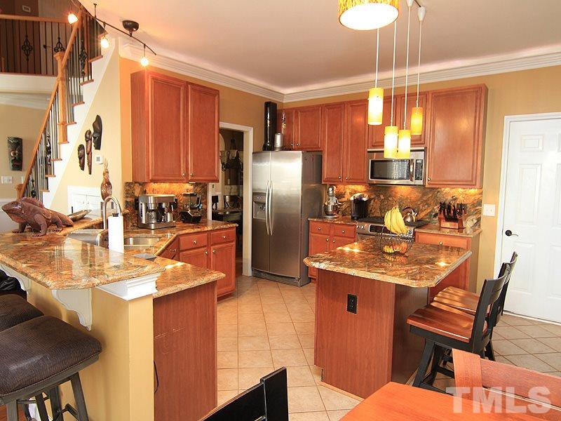 9908 Wyngate Ridge Drive Raleigh, NC 27617 - Photo 6 of 20 Completely redone, this kitchen has it all. Large, granite island, under cabinet/task lighting, stainless appliances and loads of storage. The new cabinetry boasts pull outs in every location! Don't miss cove lighting, too!