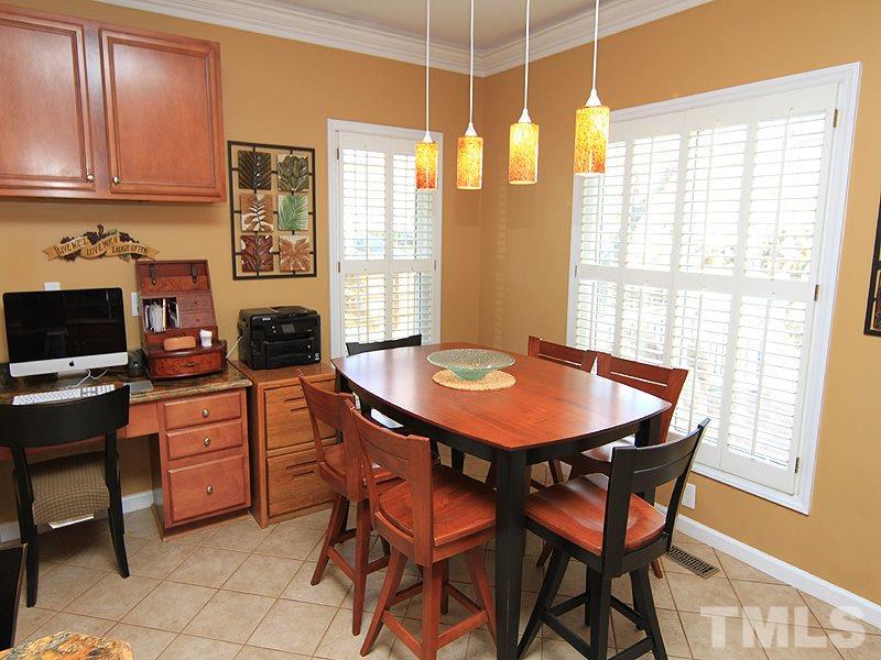9908 Wyngate Ridge Drive Raleigh, NC 27617 - Photo 8 of 20 Kitchen features tile flooring, updated pendant lighting, smart desk area and plantation shutters.