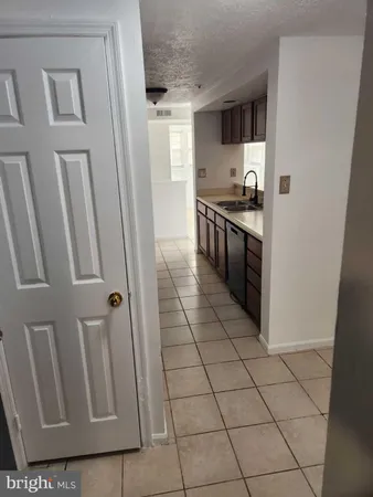 a kitchen with granite countertop a refrigerator and cabinets