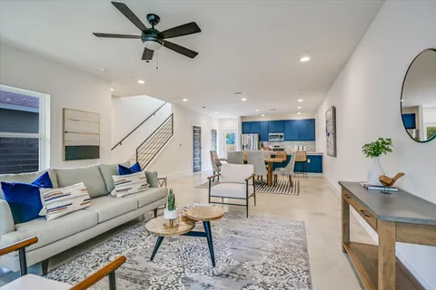a living room with furniture kitchen view and a window