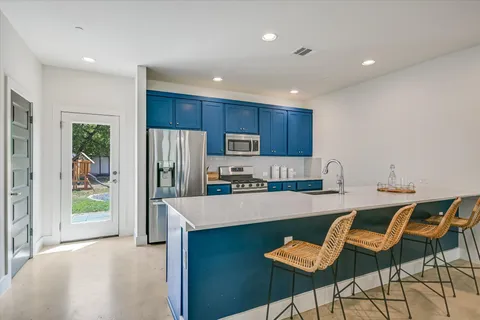 a kitchen with granite countertop a refrigerator and a sink