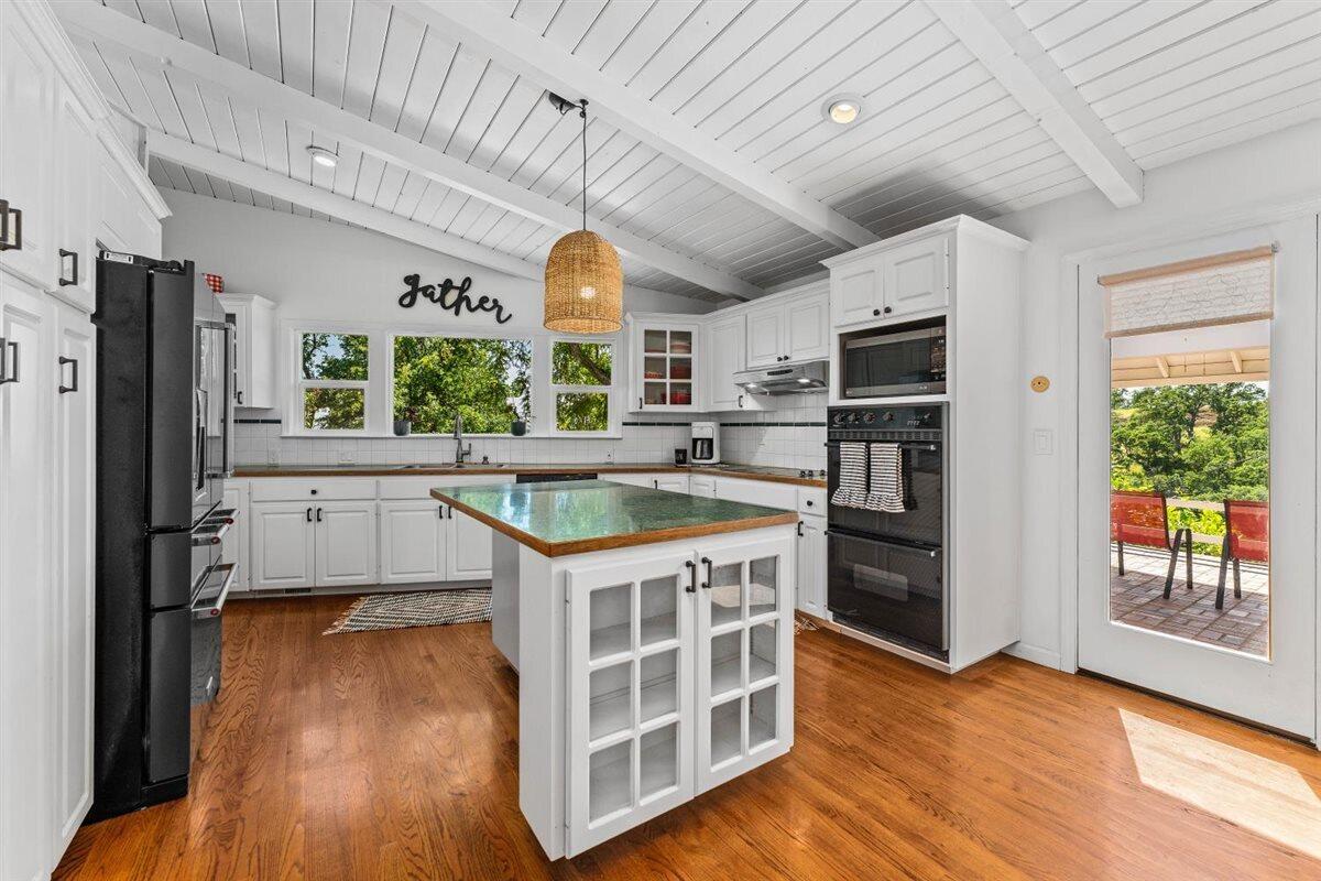 14545 Carriage Lane Red Bluff, CA 96080 - Photo 16 of 67 a kitchen with stainless steel appliances granite countertop a refrigerator a sink dishwasher a stove and a dining table with wooden floor