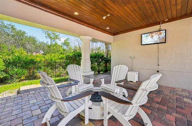a view of a patio with a table chairs and a barbeque