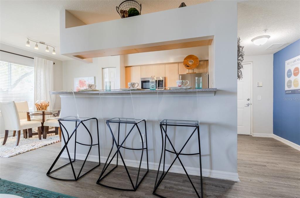 1010 Northwest Fresco Way, Unit 1B01206 Stuart, FL 34994 - Photo 7 of 47 a group of chairs sitting in a kitchen and chandelier