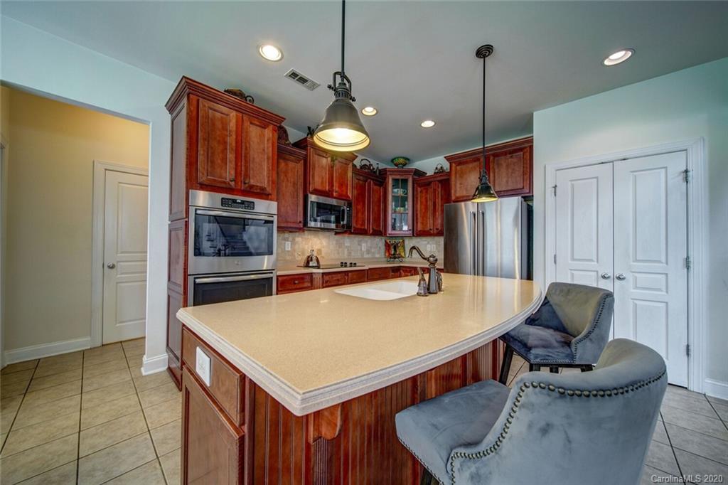 9510 Ridgeforest Drive Charlotte, NC 28277 - Photo 15 of 46 a kitchen with stainless steel appliances kitchen island granite countertop a table chairs and a refrigerator