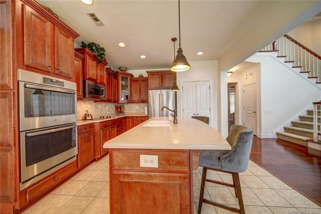 9510 Ridgeforest Drive Charlotte, NC 28277 - Photo 18 of 46 a kitchen with stainless steel appliances granite countertop a sink a stove a refrigerator cabinets and chairs