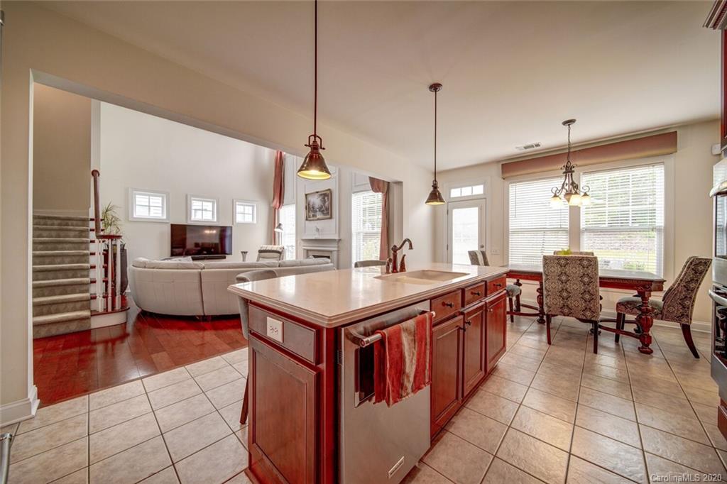 9510 Ridgeforest Drive Charlotte, NC 28277 - Photo 20 of 46 a kitchen with kitchen island a sink dining table and chairs