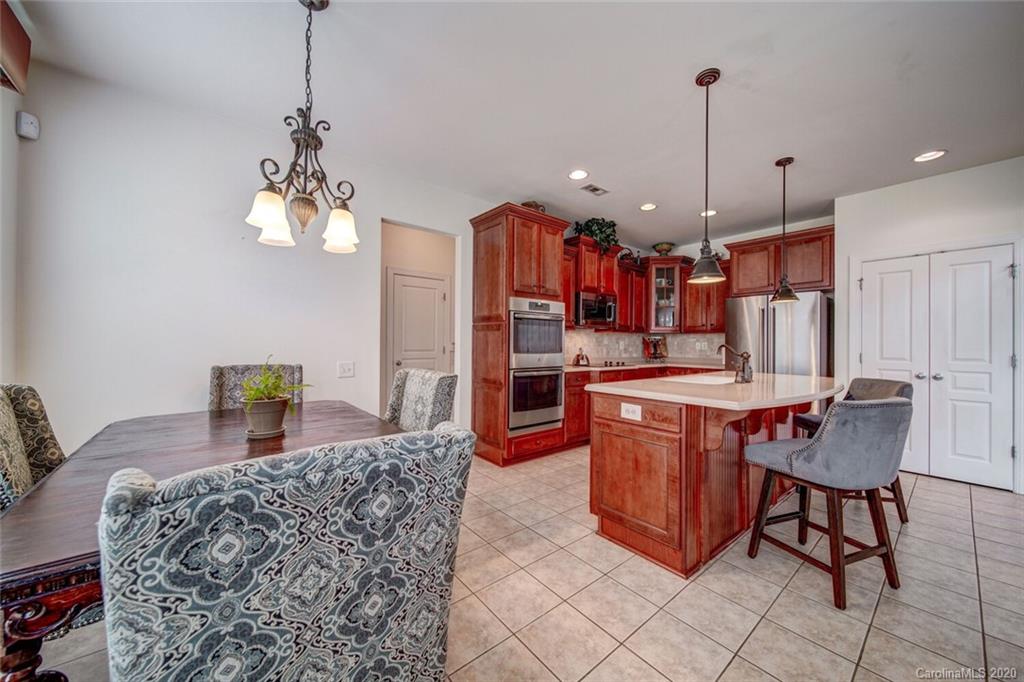 9510 Ridgeforest Drive Charlotte, NC 28277 - Photo 22 of 46 a kitchen with stainless steel appliances granite countertop a refrigerator a sink dishwasher a dining table and chairs with wooden floor