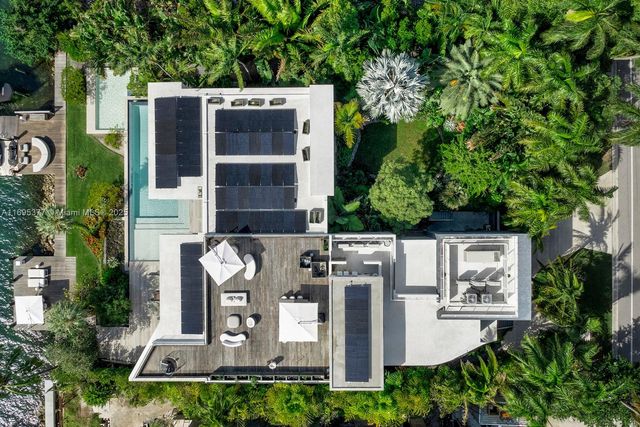 a view of a house with a yard and potted plants