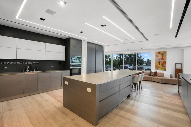 a large white kitchen with kitchen island a large counter space