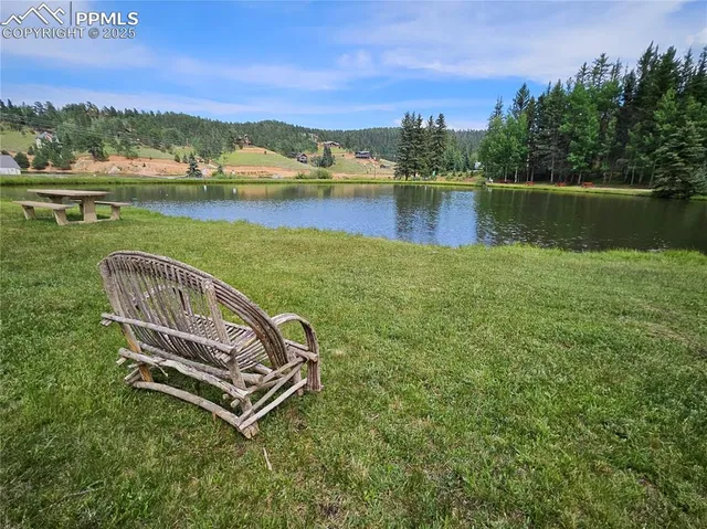 a view of a lake with a yard and a wooden fence