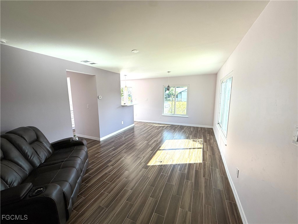 34 Hamlin Court Lehigh Acres, FL 33936 - Photo 3 of 11 wooden floor in an empty room with a window