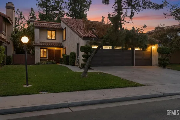a front view of a house with a yard and a road