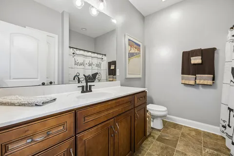 a bathroom with a granite countertop sink mirror vanity and toilet