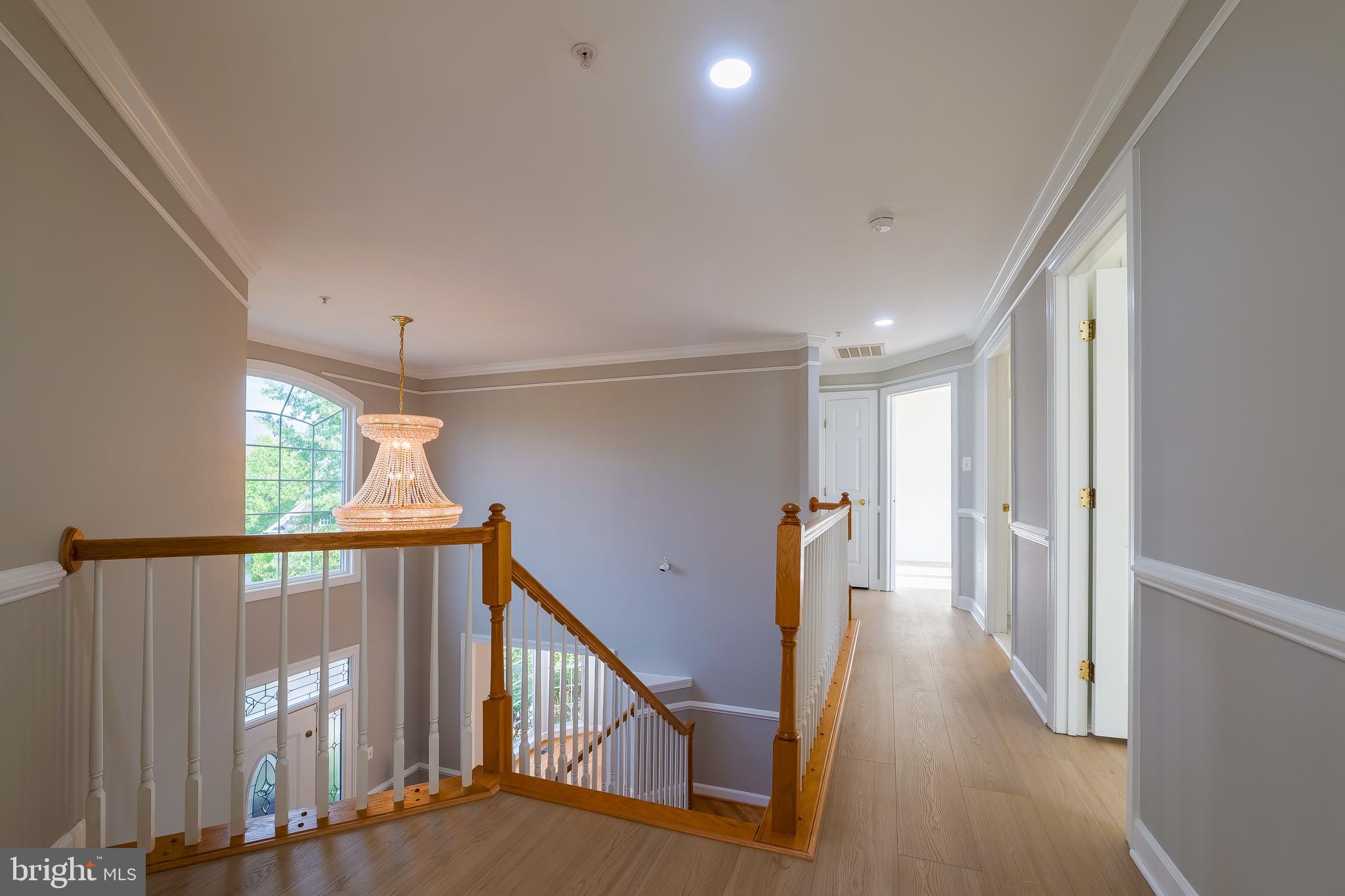 7709 Killbarron Drive Laurel, MD 20707 - Photo 24 of 79 a view of staircase with lots of frames on wall and wooden floor