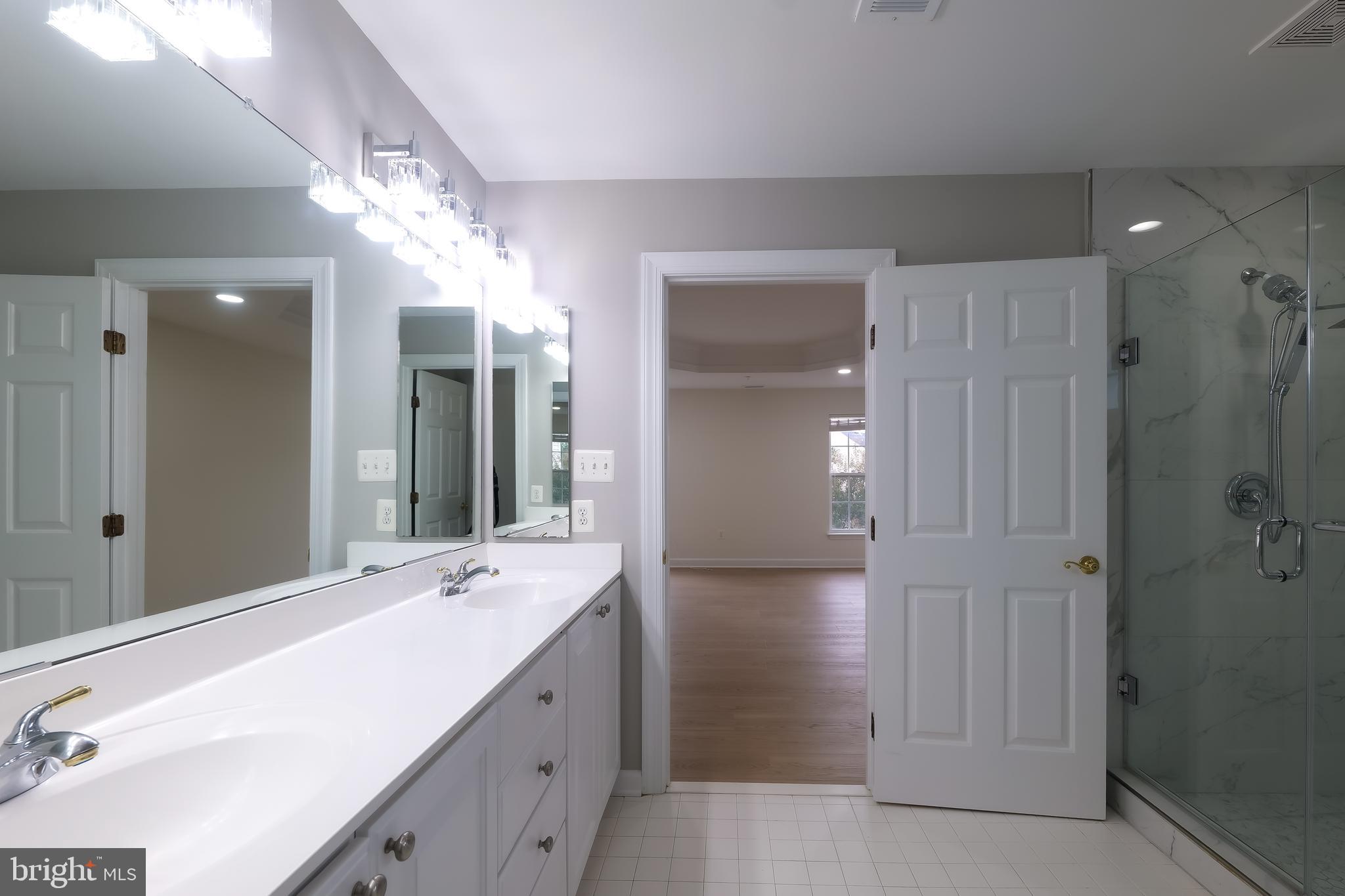 7709 Killbarron Drive Laurel, MD 20707 - Photo 28 of 79 a bathroom with a double vanity sink mirror and shower