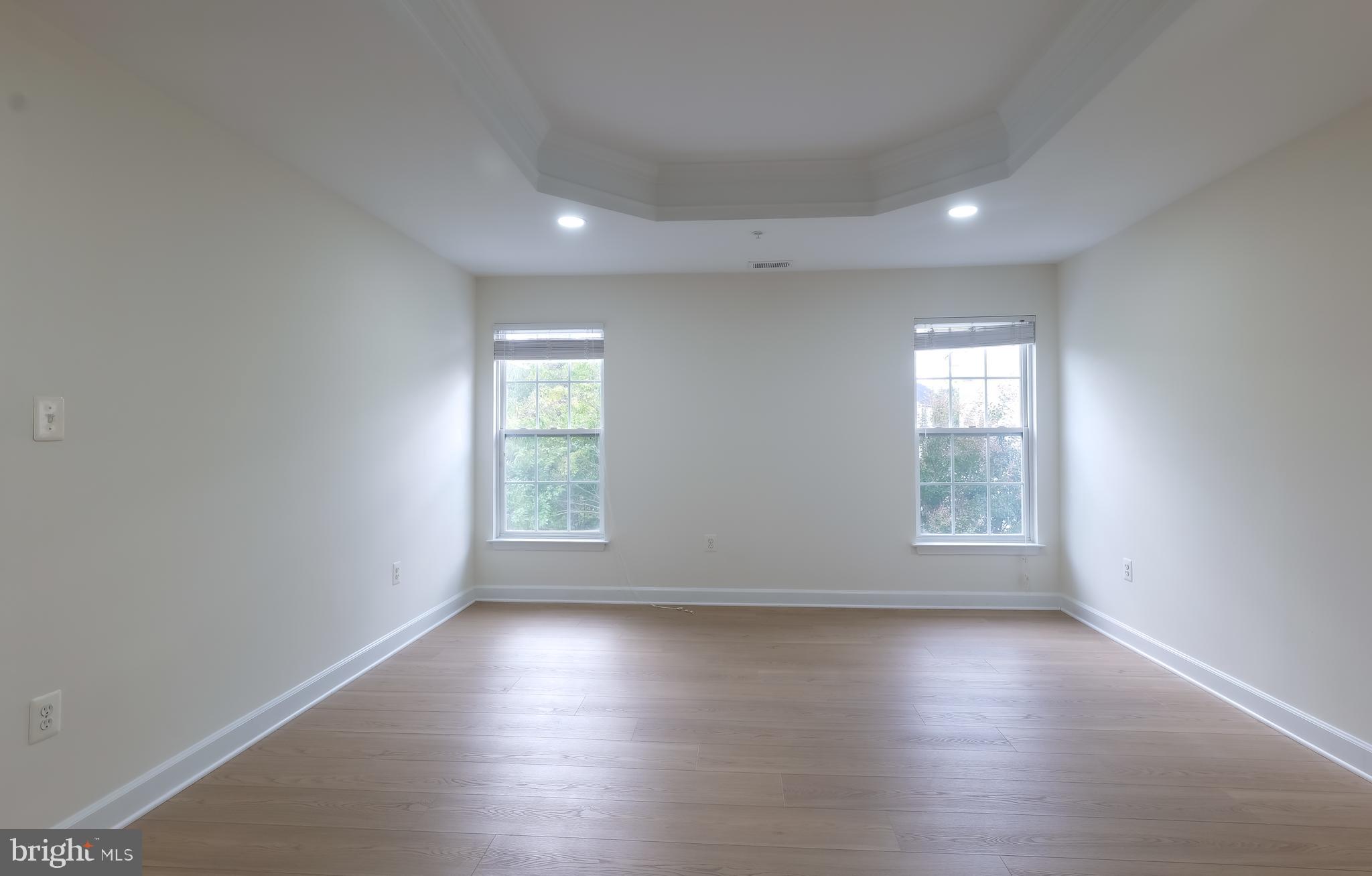 7709 Killbarron Drive Laurel, MD 20707 - Photo 31 of 79 an empty room with wooden floor and windows