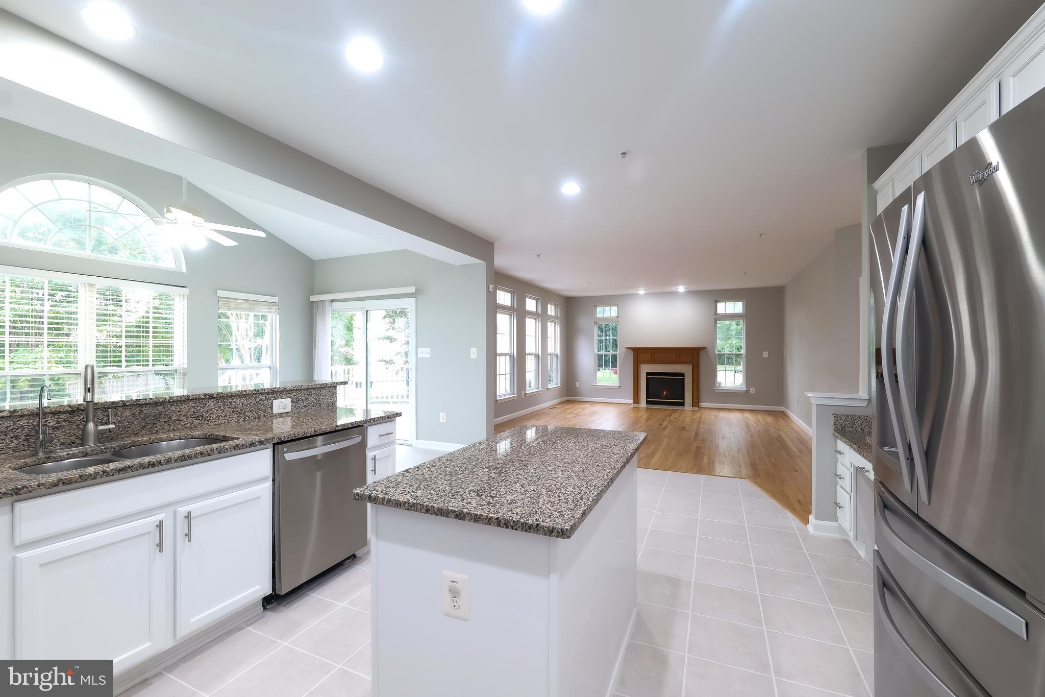 7709 Killbarron Drive Laurel, MD 20707 - Photo 52 of 79 a large kitchen with kitchen island granite countertop a large counter top stainless steel appliances a sink cabinets and a window