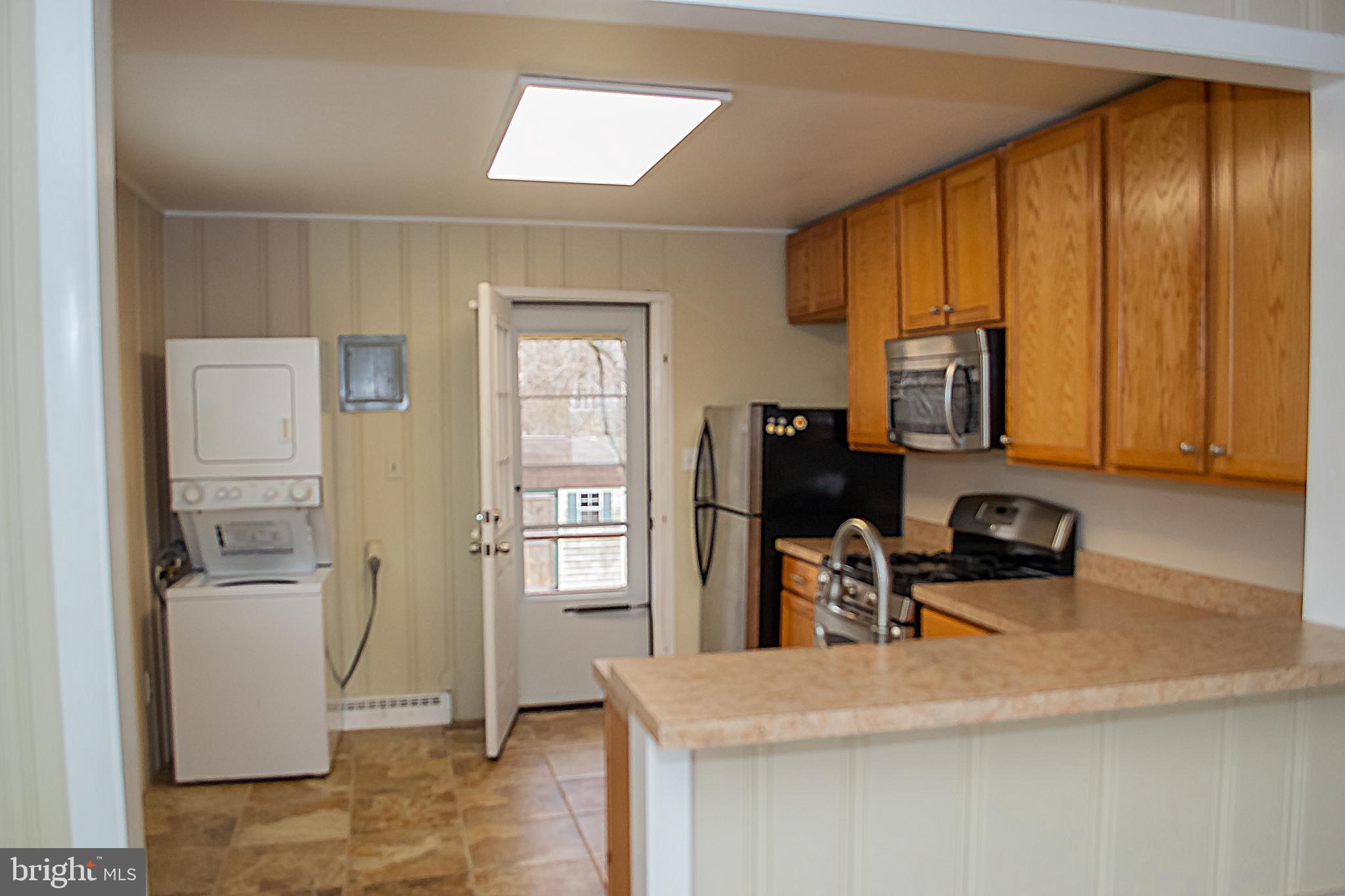217 Walnut Alley Aberdeen, MD 21001 - Photo 11 of 13 a kitchen with stainless steel appliances granite countertop a refrigerator a sink a stove and white cabinets with wooden floor