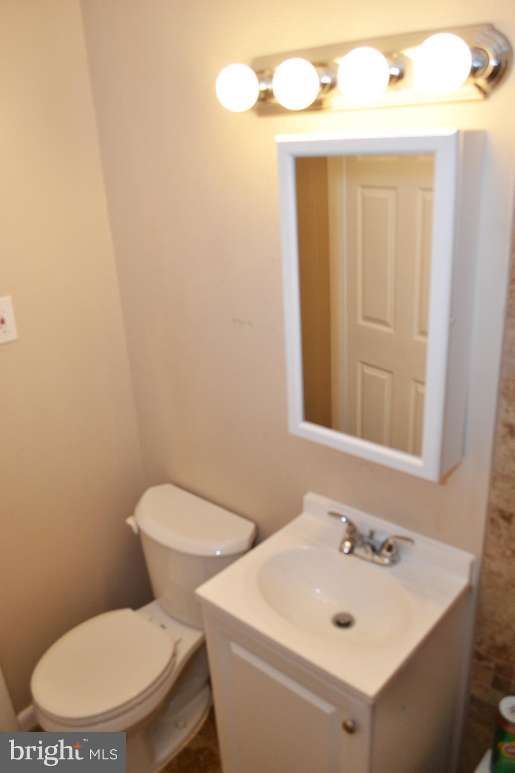217 Walnut Alley Aberdeen, MD 21001 - Photo 7 of 13 a bathroom with a toilet sink and mirror