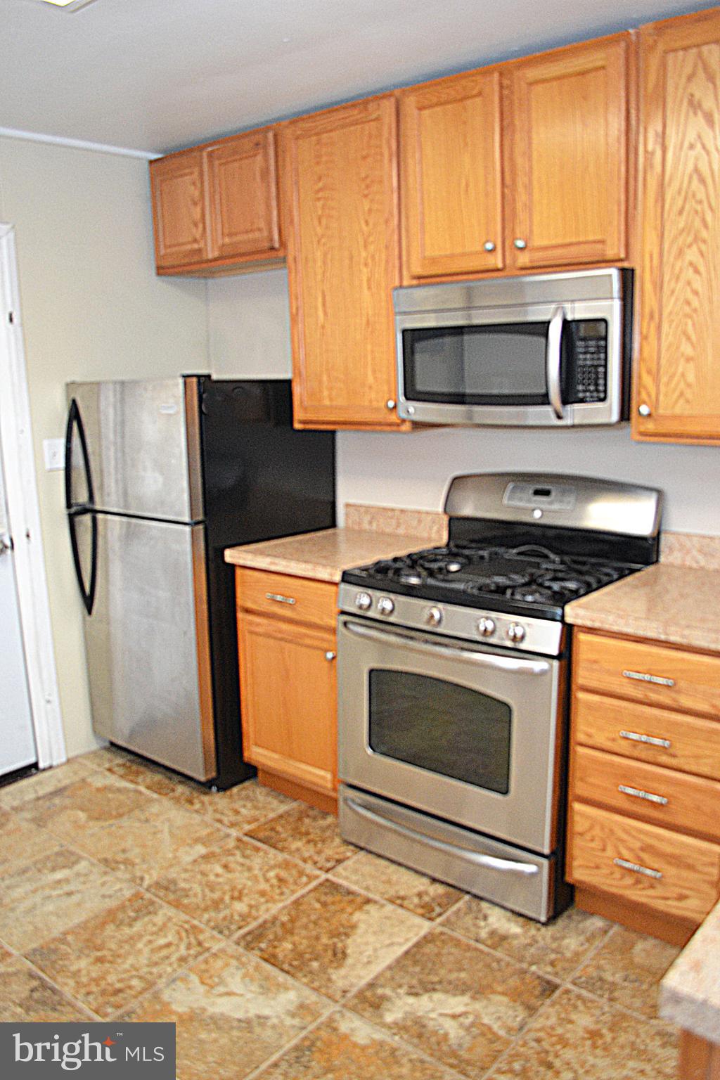 217 Walnut Alley Aberdeen, MD 21001 - Photo 8 of 13 a kitchen with granite countertop a refrigerator stove and microwave