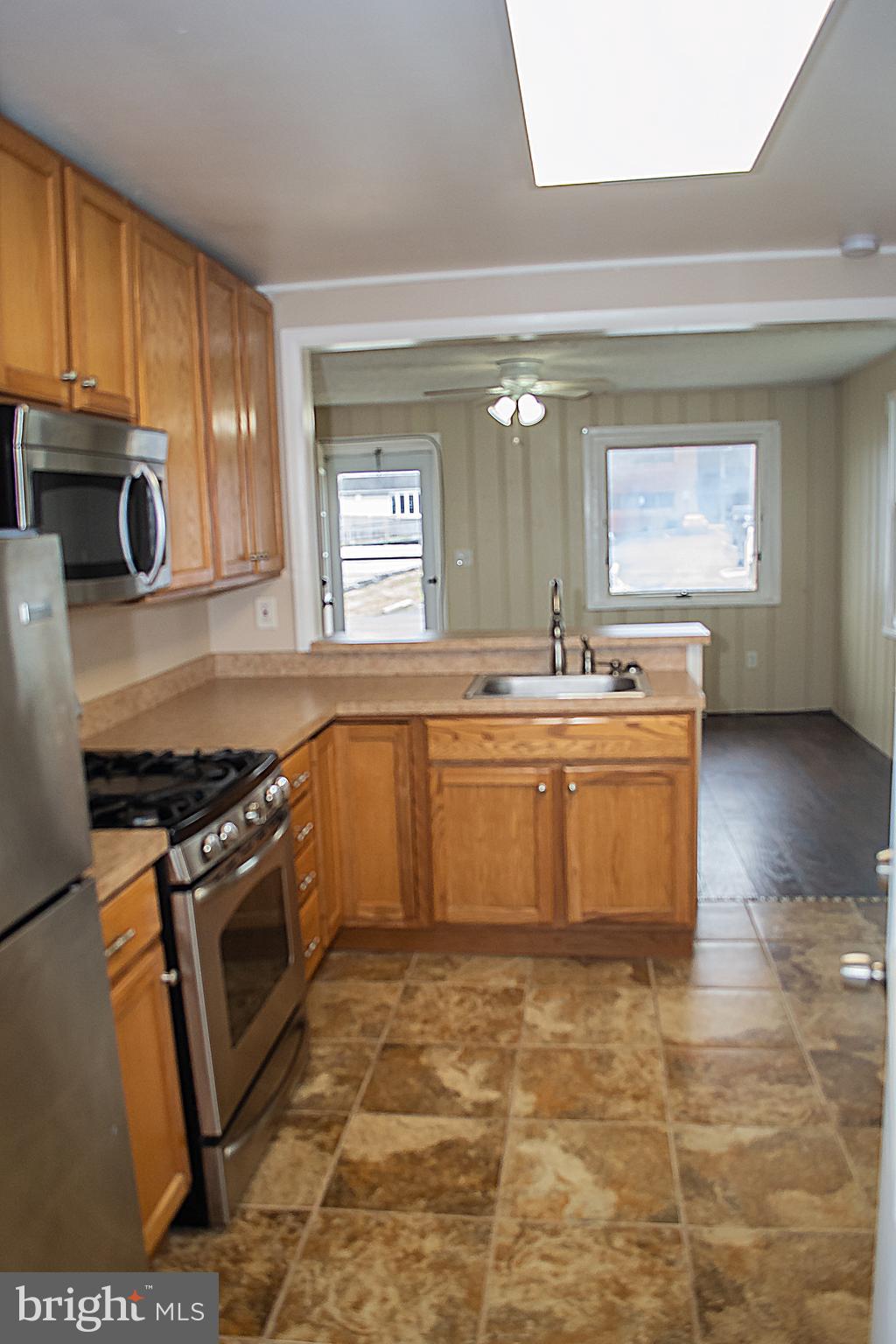 217 Walnut Alley Aberdeen, MD 21001 - Photo 10 of 13 a view of a kitchen with a sink wooden cabinets and a window