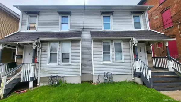 a brick house with a small yard and a large window