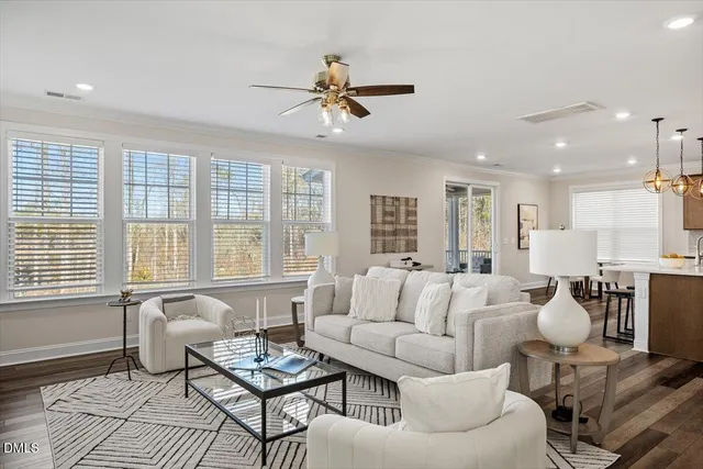 a dining room with furniture a potted plant and wooden floor